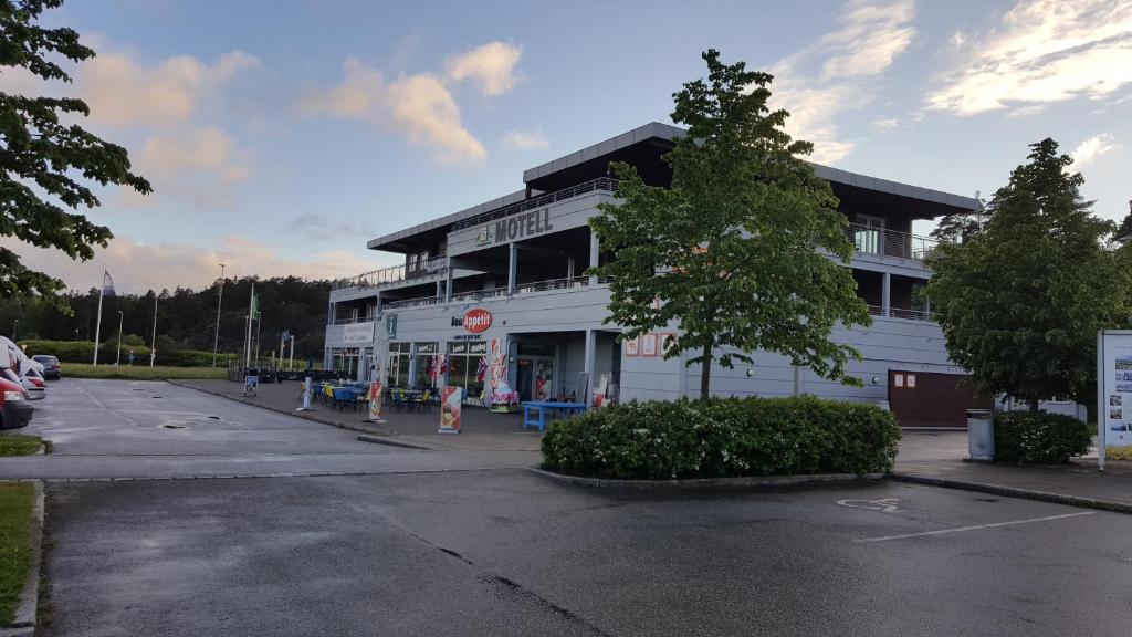 ein Parkplatz vor einem weißen Gebäude in der Unterkunft Motell Svinesundparken in Halden