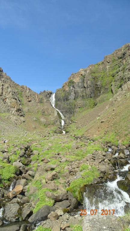 a mountain with a waterfall on the side of it at Miðjanes Reykhólahrepp in Reykhólar