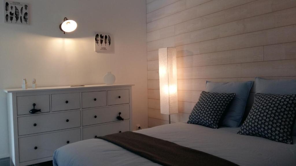 メール・レ・バンにあるVilla Helvetia Wifiのベッドルーム1室(木製ヘッドボード付きのベッド1台、ドレッサー付)