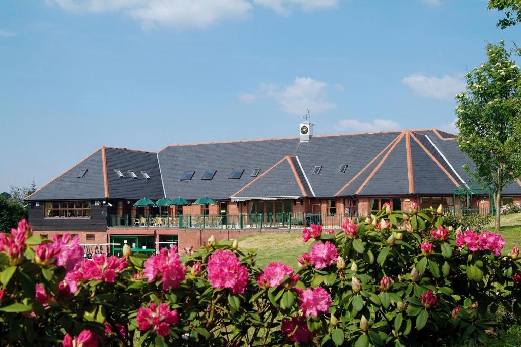 ein großes Gebäude mit rosa Blumen davor in der Unterkunft Wharton Park Golf & Country Club in Bewdley