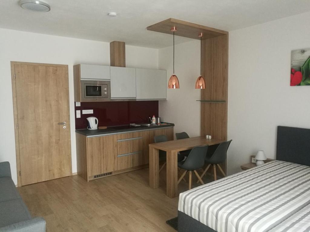 sypialnia z łóżkiem i kuchnia ze stołem w obiekcie Apartmány Sport Dolní Morava w mieście Dolní Morava