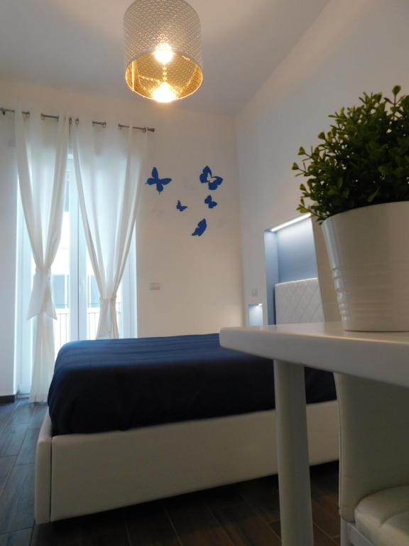 ein Schlafzimmer mit einem Bett und einem Tisch mit einer Topfpflanze in der Unterkunft CIVICO 29 in Pompei