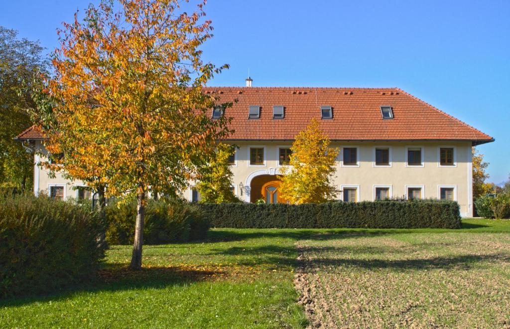 a large white building with a red roof at Bauernhofpension Herzog zu Laah in Linz