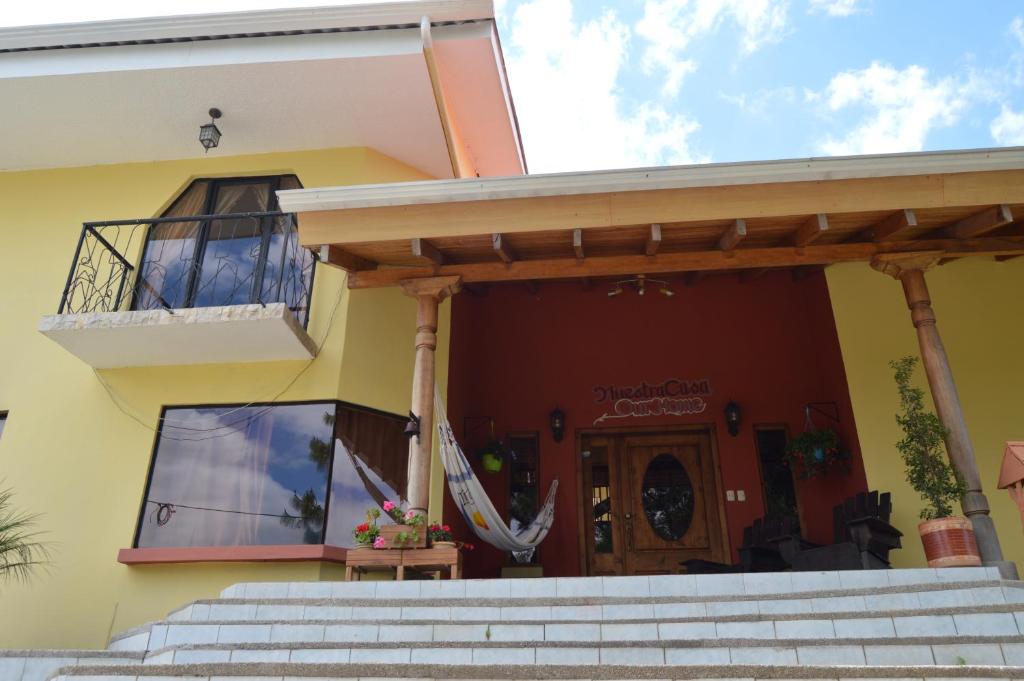 a yellow house with a balcony and stairs at NUESTRA CASA - OUR HOME Cuenca by A2CC in Ricaurte