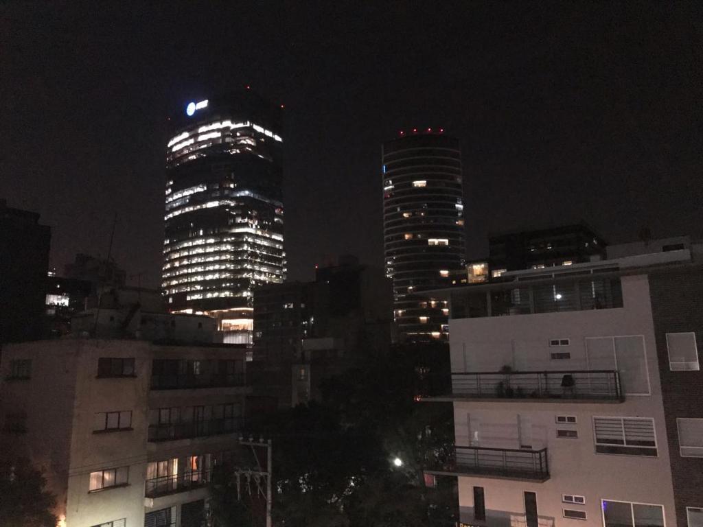 dos edificios altos en una ciudad por la noche en Departamentos Pánuco, en Ciudad de México