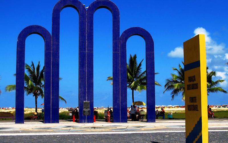 a group of blue pillars with palm trees in the background at Aracaju Temporada in Aracaju