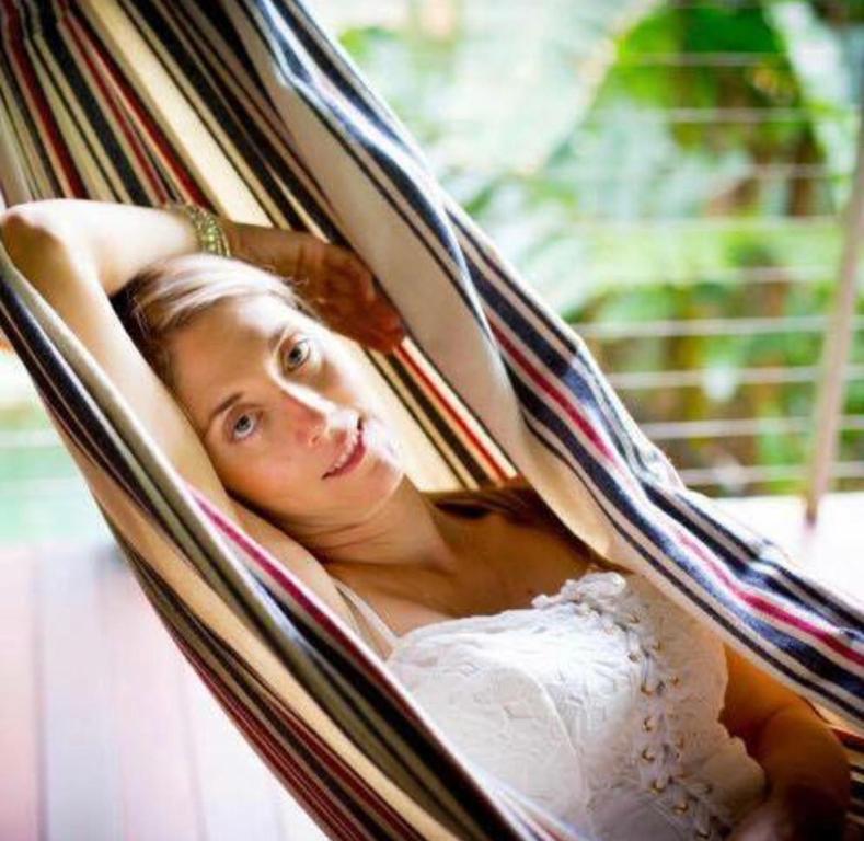 a woman in a wedding dress laying in a hammock at Treetops Retreat Cairns in Cairns