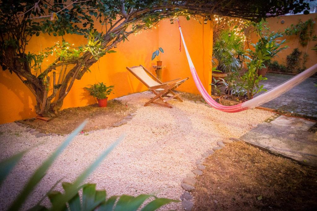 une balançoire dans un jardin avec un mur jaune dans l'établissement Casa Loritos, à Cancún
