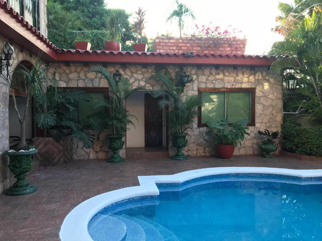 a house with a swimming pool in front of a house at Casa Costera Miguel Alemán in Acapulco