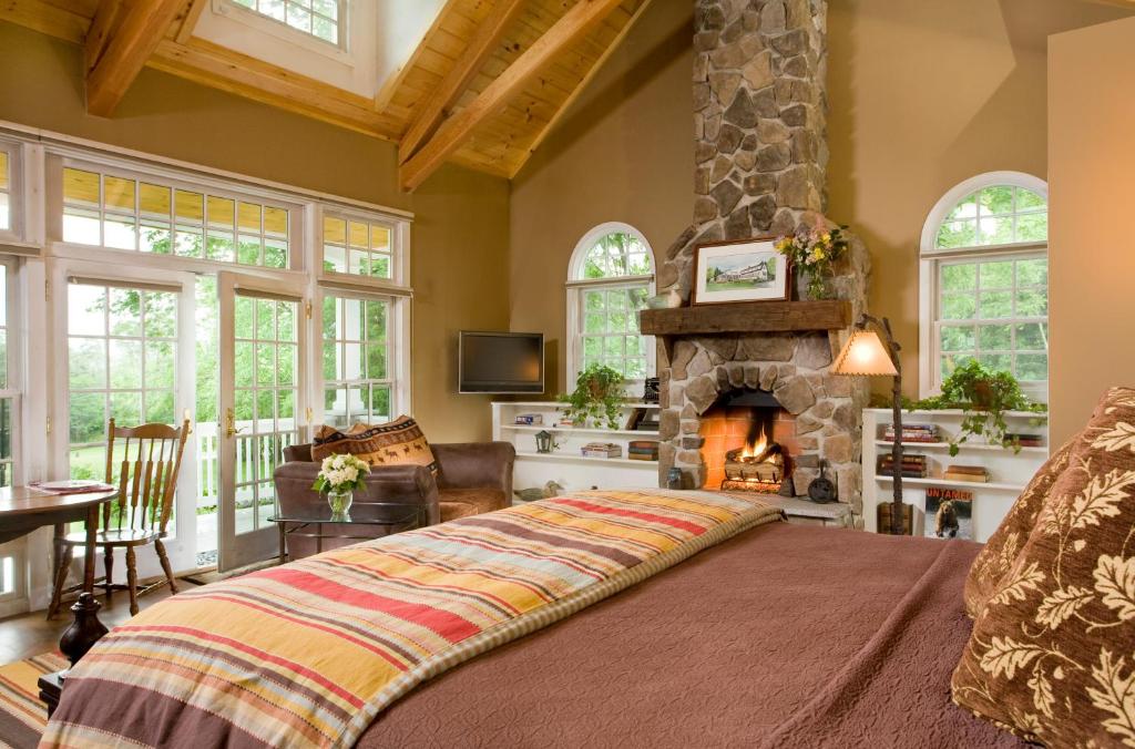 a bedroom with a large bed and a fireplace at Sugar Hill Inn in Sugar Hill