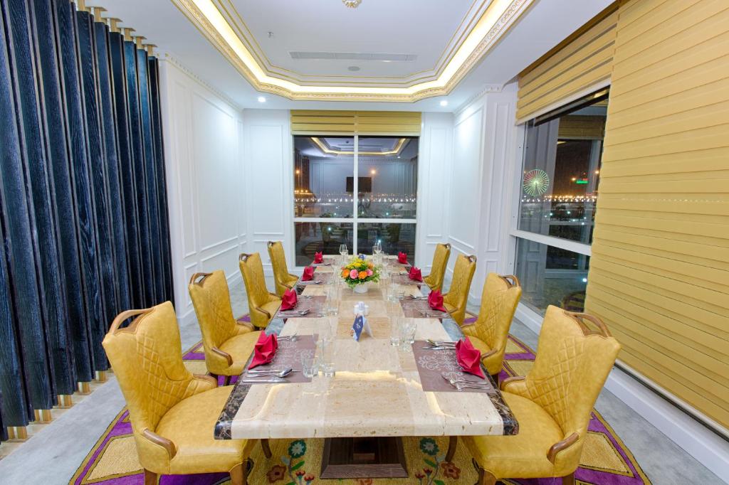 A formal private dining room set for a group meal beside nighttime windows.