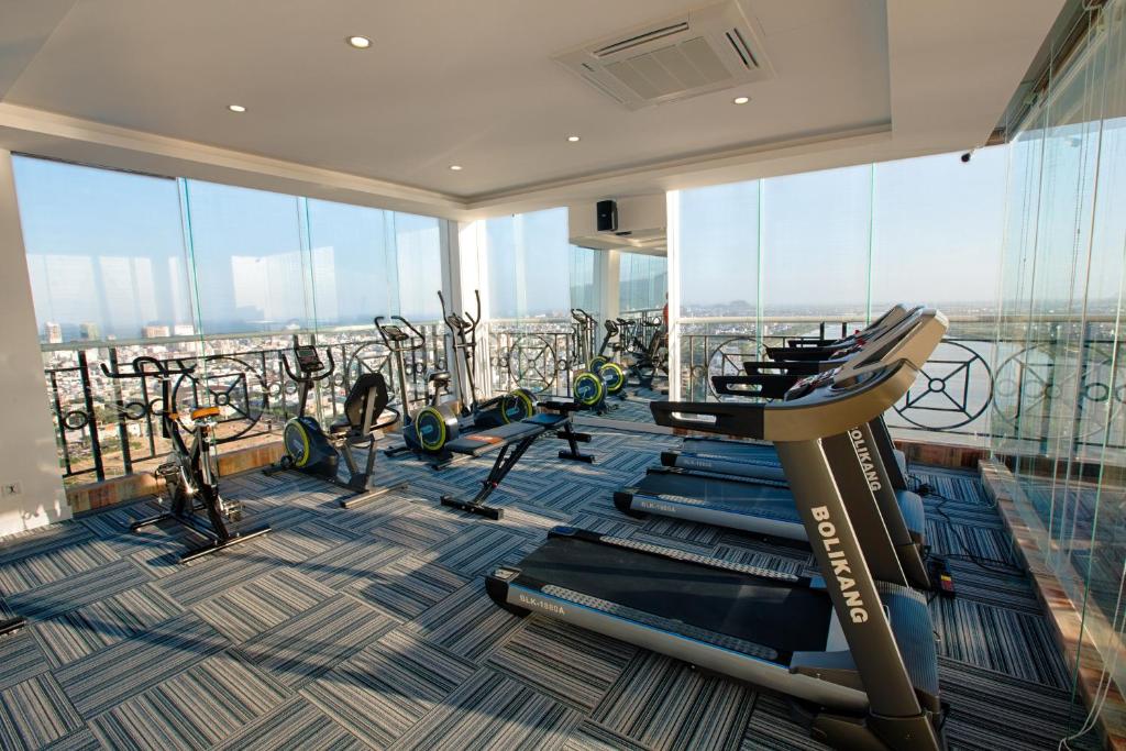 A glass-walled gym contains treadmills, stationary bikes, and other cardio equipment overlooking the city.