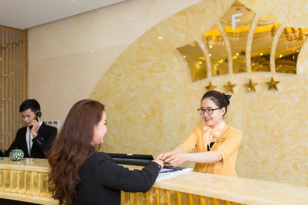 A polished reception desk where a guest is being assisted by a staff member.