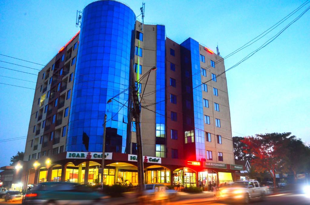 a building with a blue reflection on the side of it at Igar Plaza Hotel in Jinja