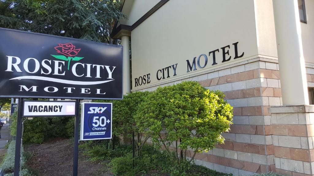 ein Schild für ein Rose City Motel neben einem Gebäude in der Unterkunft Rose City Motel in Palmerston North