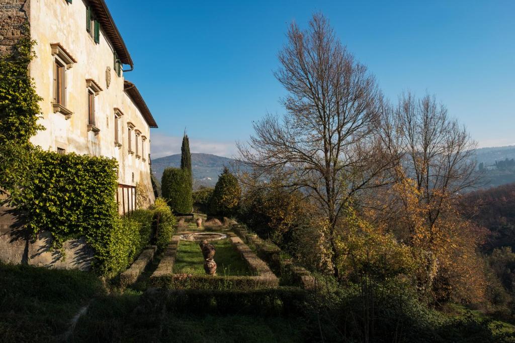 a building with a garden next to a building at Enchanting Medici's Mansion 7 min from Florence in Fiesole