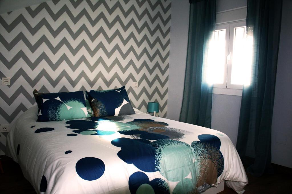 a bedroom with a large bed with a chevronuitous sqor at Precioso Ático céntrico - El Palomar in Valladolid