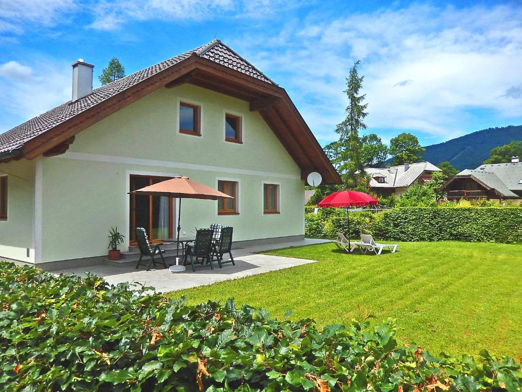 uma casa branca com uma mesa e cadeiras num quintal em Haus Seehof - Ferienhaus em Abersee