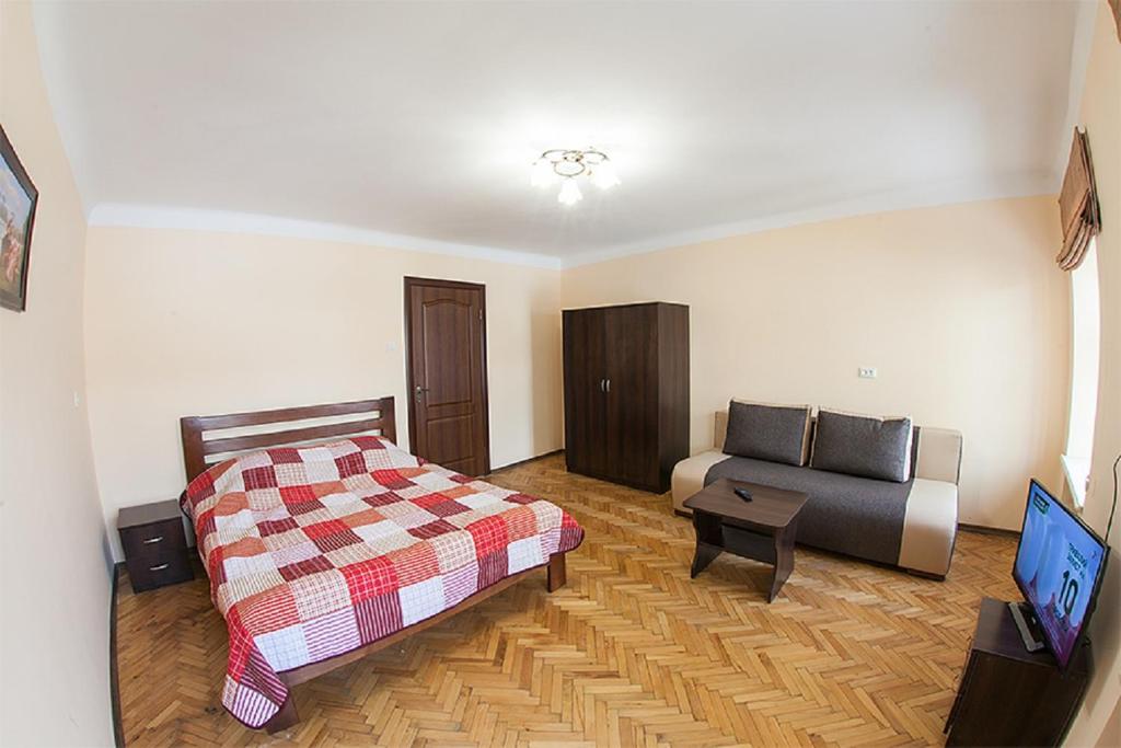 リヴィウにあるКвартира в центрі на вулиці Вірменській 12 є дві спальні двуспальні ліжкаのベッドとソファ付きのホテルルーム