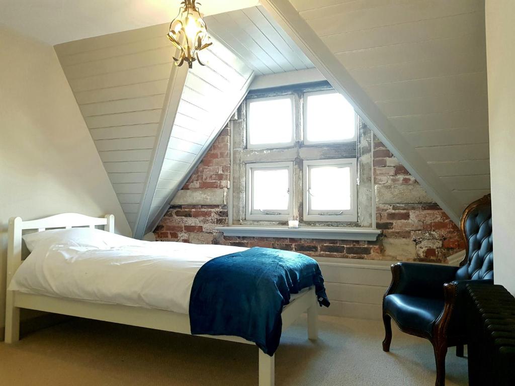 1 dormitorio en el ático con cama y ventana en Camelford House, en Brighton & Hove