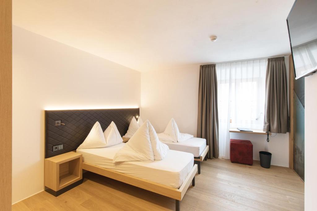A bed or beds in a room at Belvenu Boutique Hotel