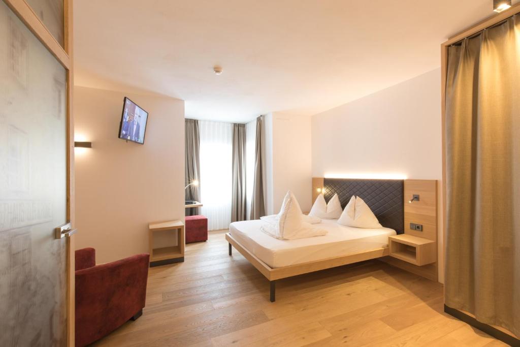 A bed or beds in a room at Belvenu Boutique Hotel