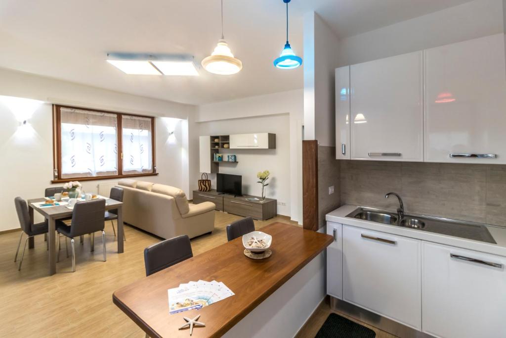 una cucina e un soggiorno con un tavolo e una sala da pranzo di Zaffiro Luxury Silvi Vacanza a Silvi Marina