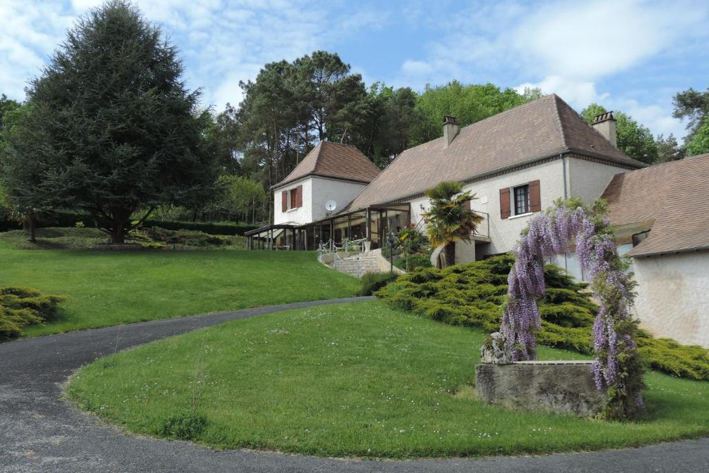 a house with a garden in front of a driveway at Le jardin des paons in Issac