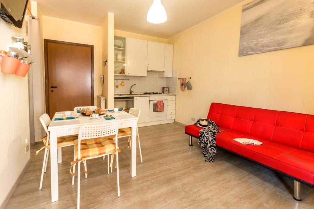 uma sala de estar com um sofá vermelho e uma mesa em Stella Marina Silvi Vacanza em Silvi Marina