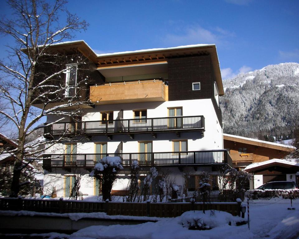 ein Gebäude mit Balkon im Schnee in der Unterkunft Gästehaus Maier in Kitzbühel