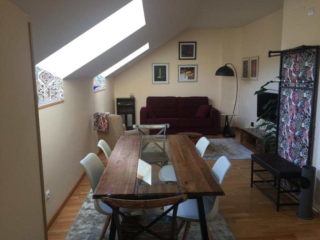 uma sala de estar com uma mesa de madeira e cadeiras em Apartamento Conde Luna em León