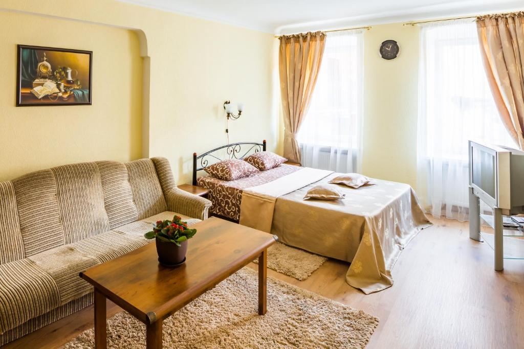 ein Wohnzimmer mit einem Bett und einem Sofa in der Unterkunft Apartment Krakivska 15 in Lwiw