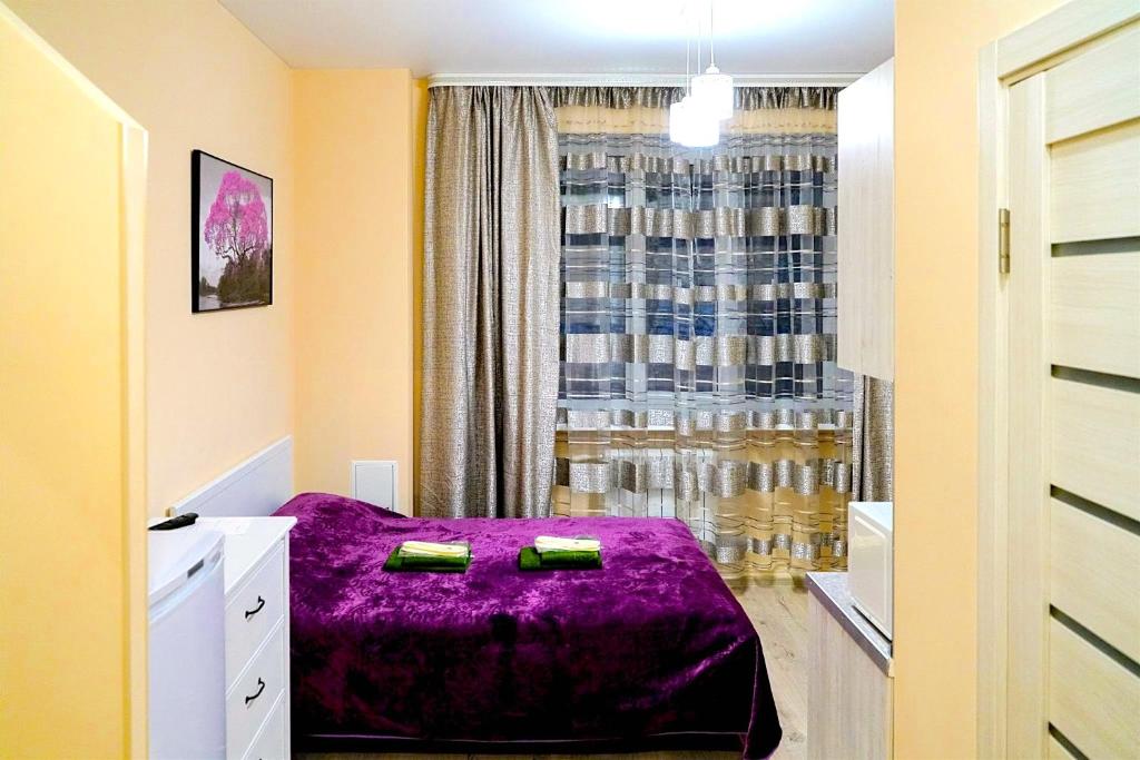 ポドリスクにあるApartment Dianaの窓の前に紫色のベッドが備わるベッドルーム1室