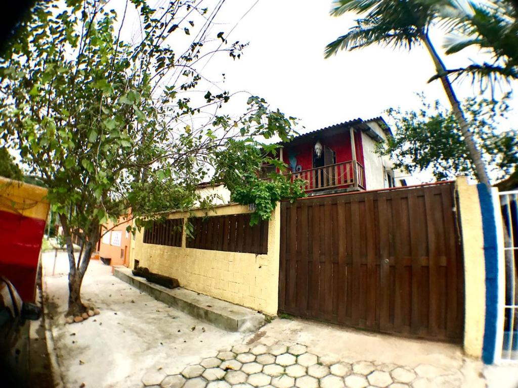 una casa con una puerta de madera y una valla en Pousada Tia Cleide en Caraguatatuba