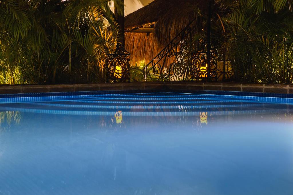 una piscina de agua azul frente a una casa en La Leyenda Boutique Hotel by Bunik en Playa del Carmen