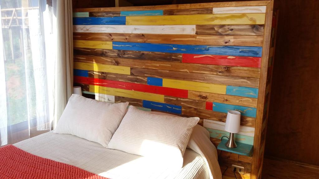 1 dormitorio con pared de madera en Carilafquen Habitaciones en Suite, en Valparaíso