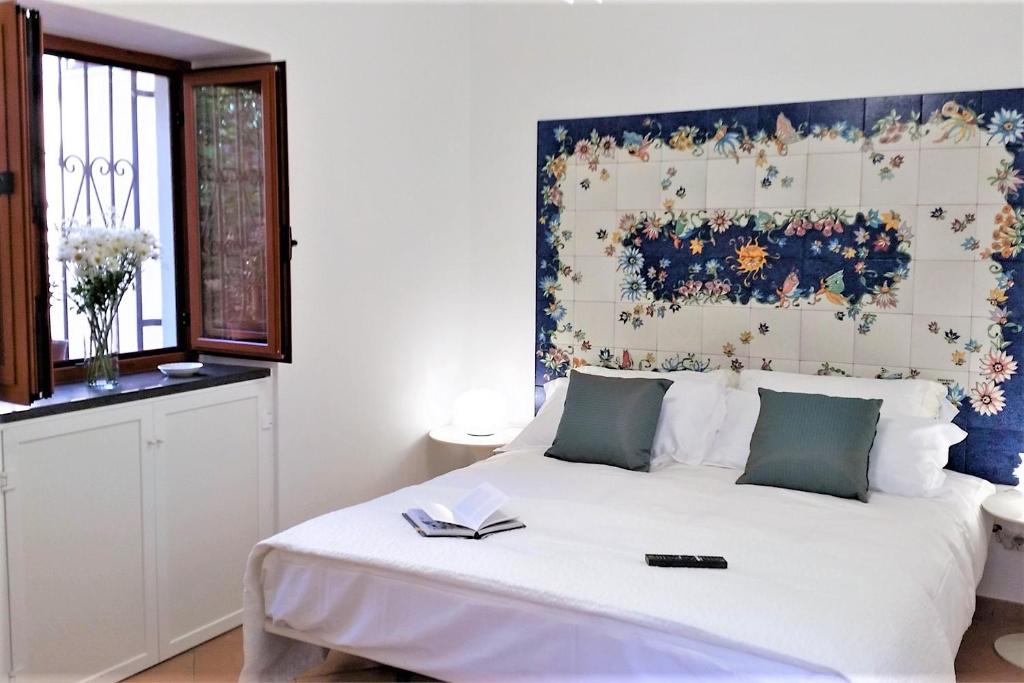 チェターラにあるLa Corte dei Naviganti B&B - Amalfi Coast - Cetaraのベッドルーム(花柄のヘッドボード付きの大きな白いベッド1台付)