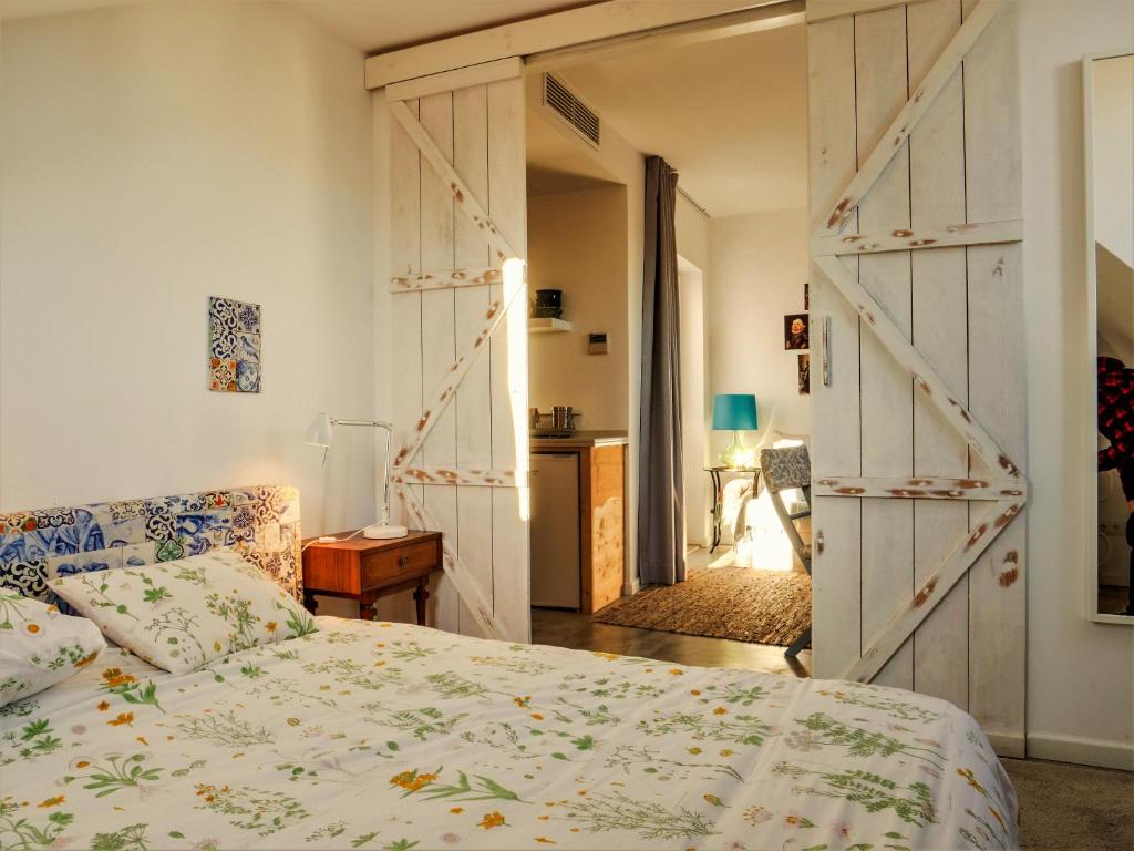 リスボンにあるApartments Uppe Villaのベッドルーム1室(ベッド1台付)、納屋のスライドドアが備わります。