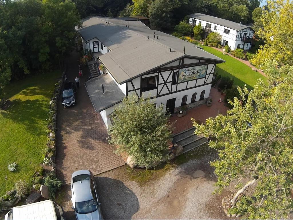 une vue aérienne sur une maison avec une voiture garée devant dans l'établissement Gutspark Seeblick, à Kägsdorf