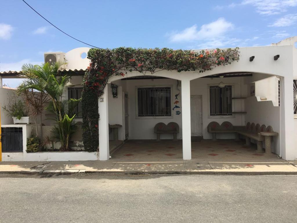 a white house with an arch with flowers on it at NUESTRA CASA-OUR HOME Salinas by A2CC in Salinas