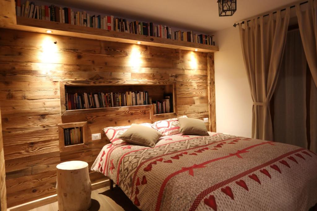 Un dormitorio con una pared de madera y una cama en Al Papavero en Andalo