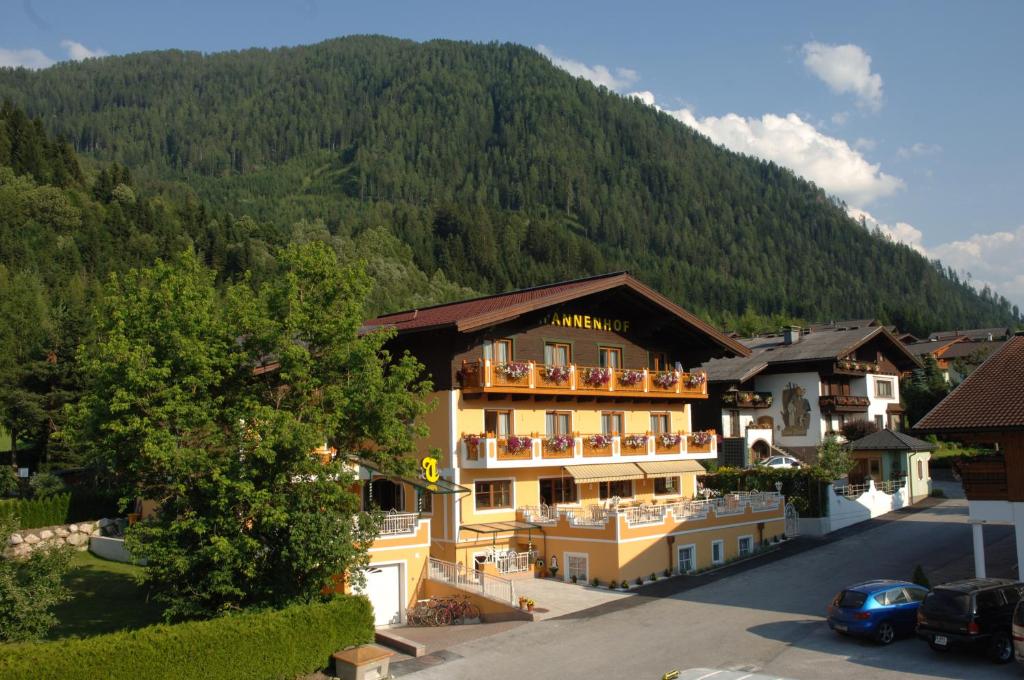 un grand bâtiment en face d'une montagne dans l'établissement Hotel Garni Tannenhof, à Flachau