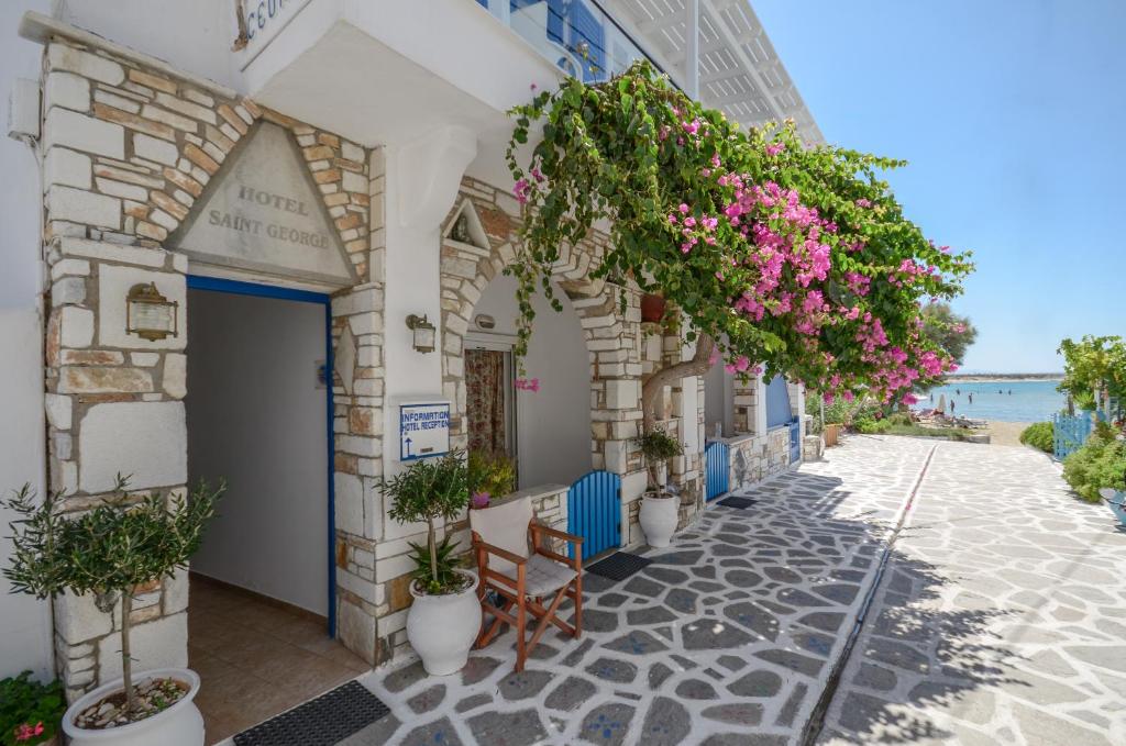
a beach scene with a balcony and a building at Saint George Hotel in Naxos Chora

