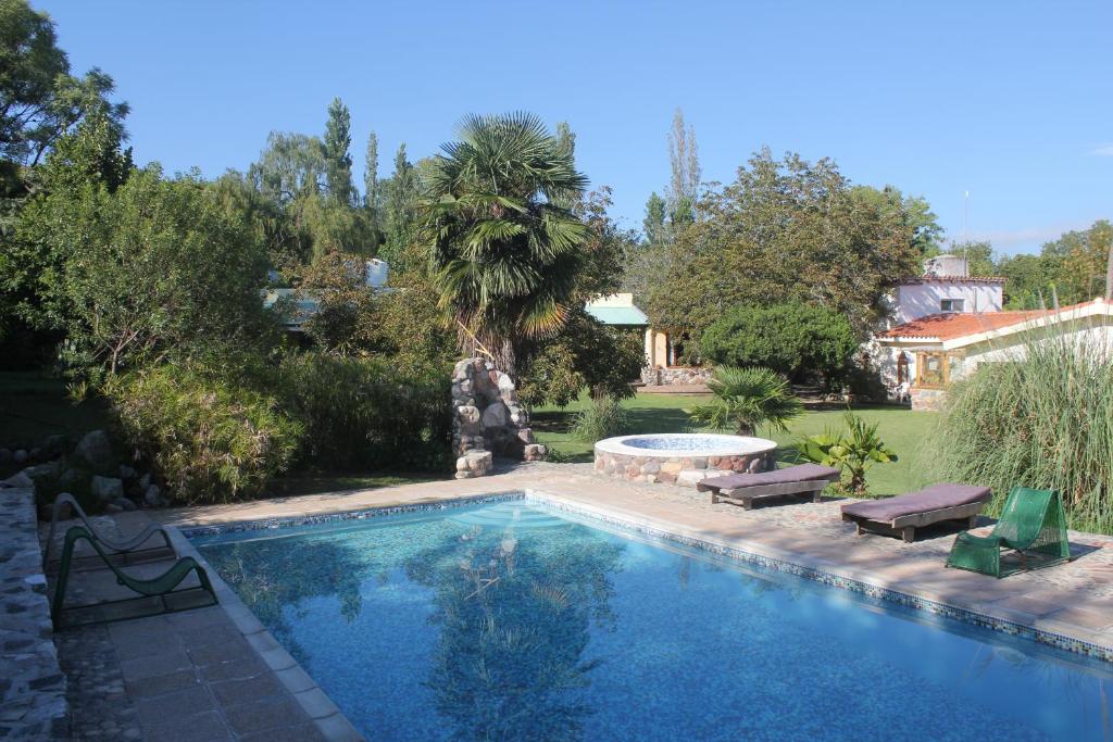 una piscina in un cortile con 2 sedie a sdraio e una piscina di La Casa de Wanda a Villa Las Rosas
