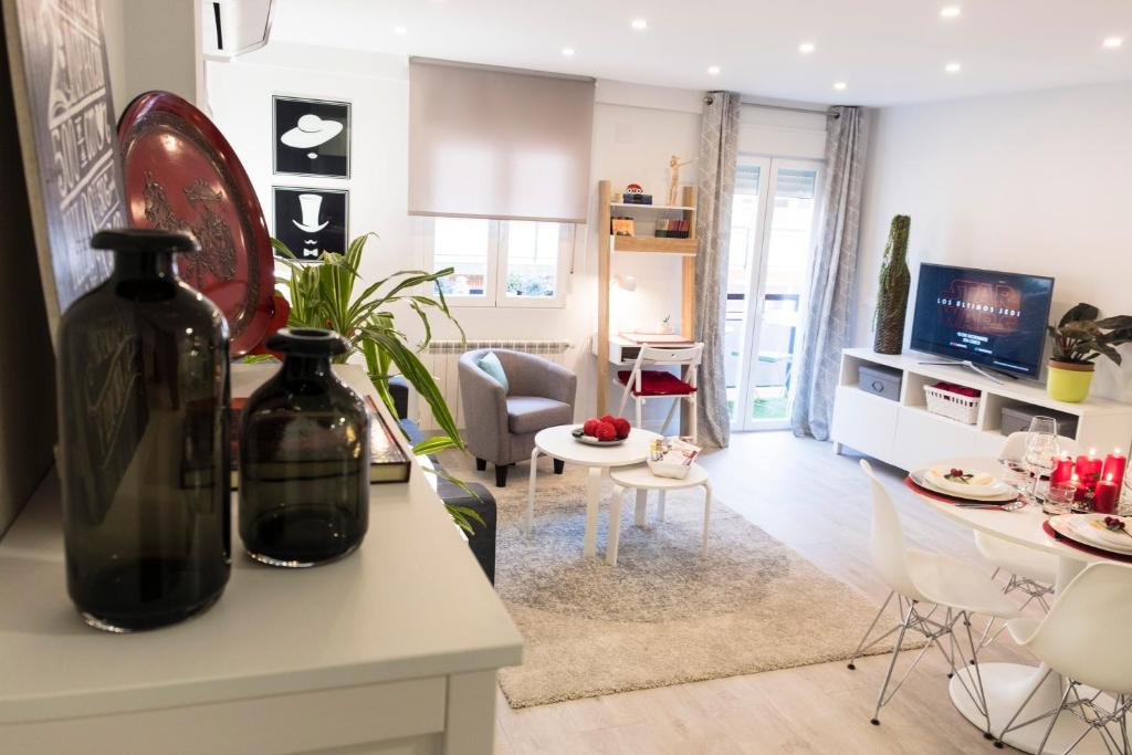 a living room with a kitchen and a living room with a table at Apartamento Garval Valladolid in Valladolid