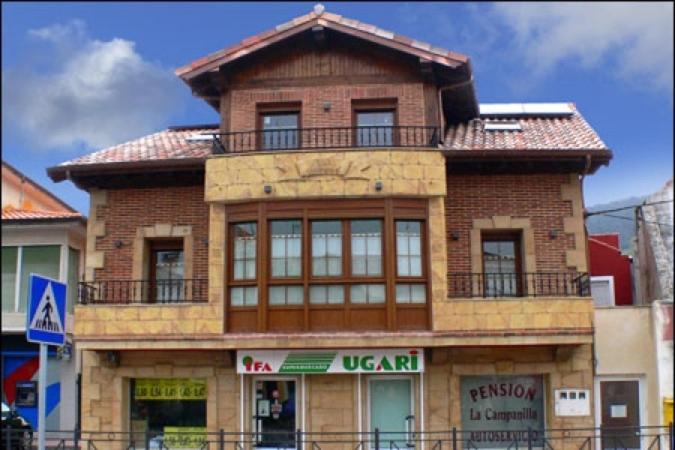 un edificio de ladrillo con balcón en la parte superior en Pensión la Campanilla en La Penilla