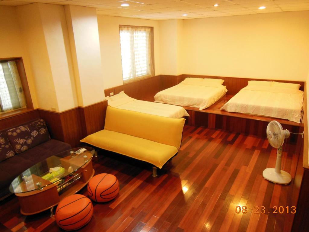 花蓮市的住宿－信義之家，一间设有两张床、一张沙发和篮球的房间