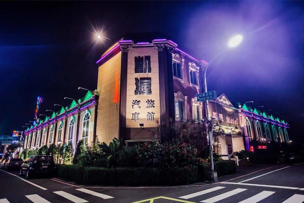 um edifício com luzes sobre ele em uma rua à noite em Catwalk Motel -Tainan em Tainan