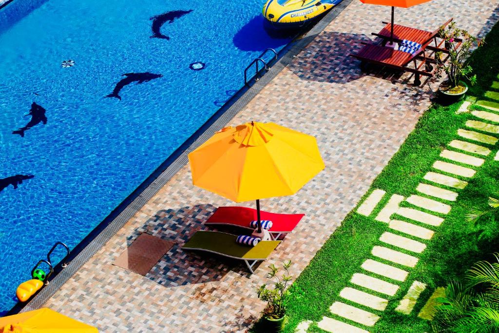 an overhead view of a swimming pool with umbrellas at Hotel White House in Anuradhapura