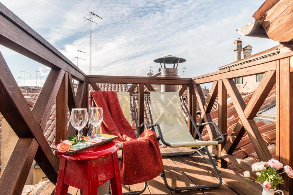 balkon z 2 krzesłami i stołem z kieliszkami do wina w obiekcie Rialto Mini w Wenecji